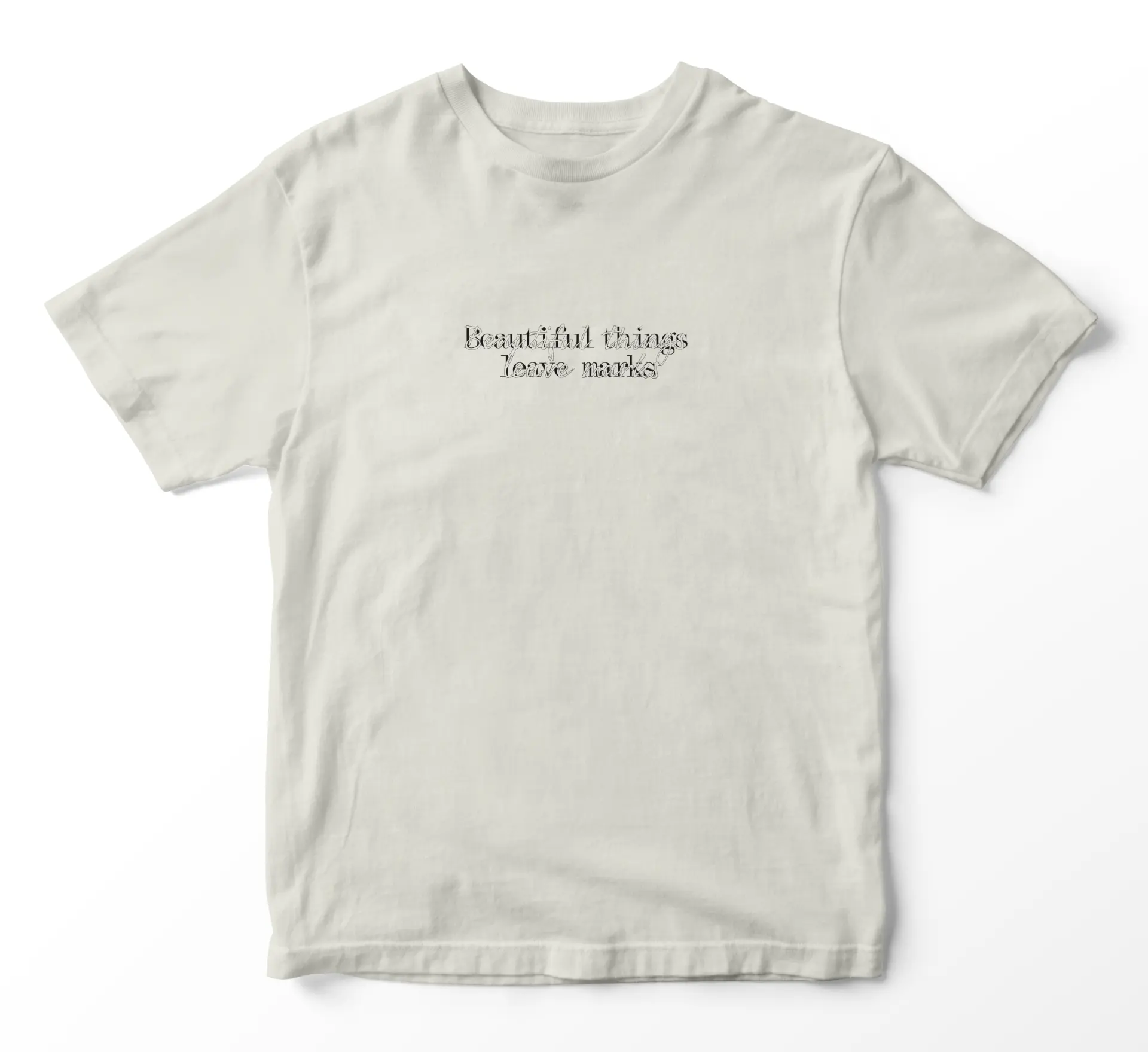 Close crop of the shirt print reading “Beautiful things leave marks”
