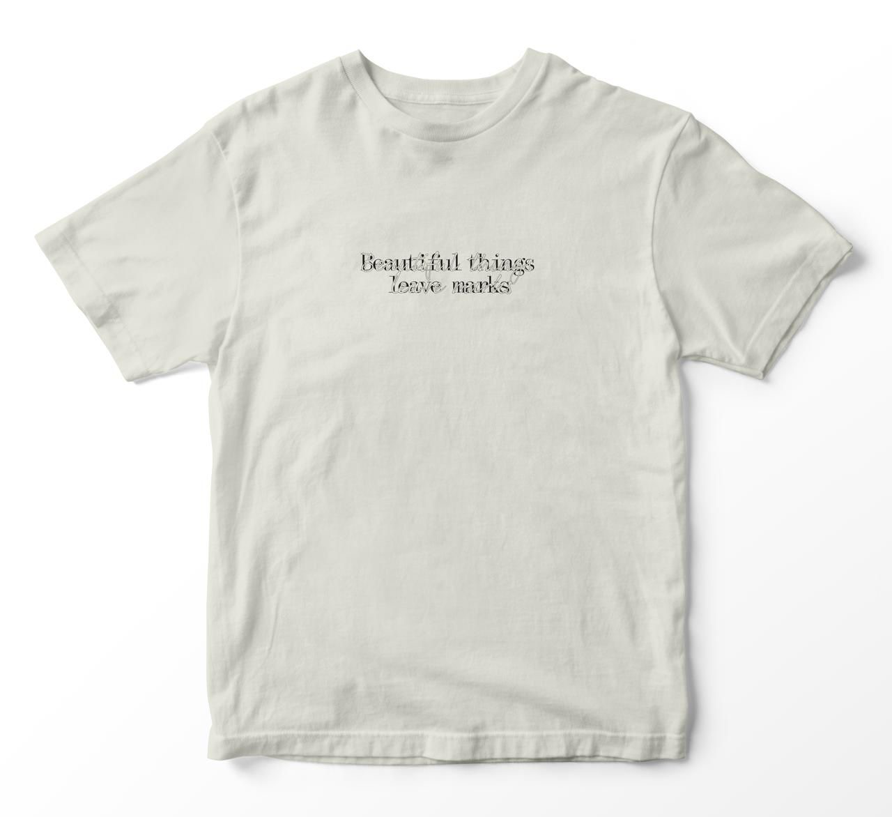 Front of the off-white shirt with the print “Beautiful things leave marks”